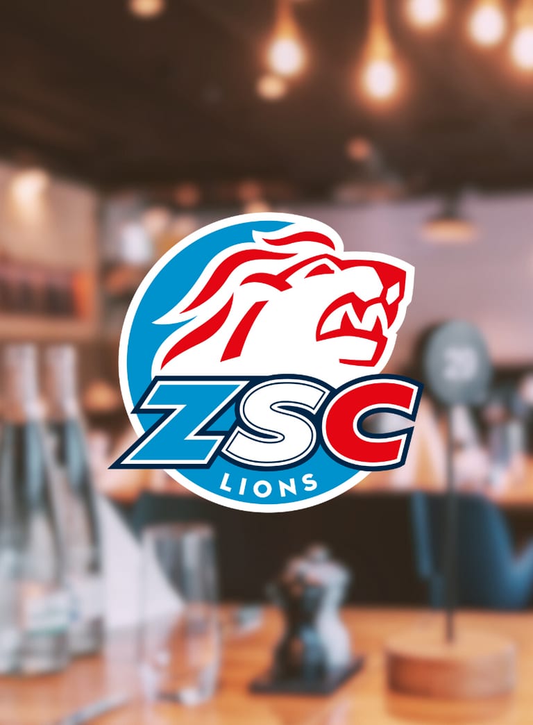 ZSC Lions-Logo über unscharfem Restaurantinterieur.