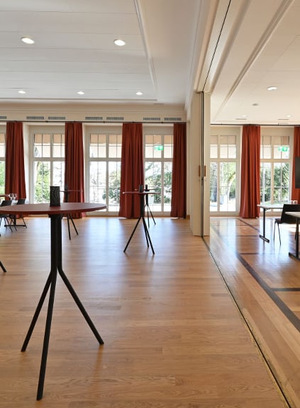 Leerer Konferenzraum mit Fenstern und Vorhängen.