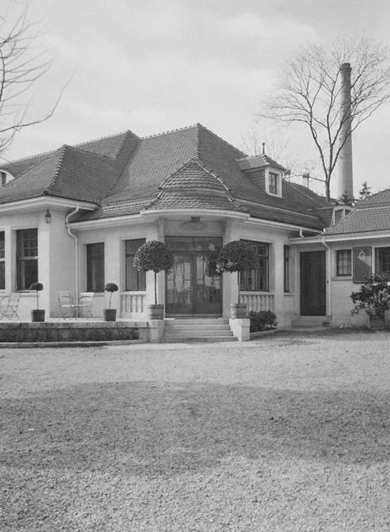 Historische Villa mit Rundbogenfenstern und Kiesweg.