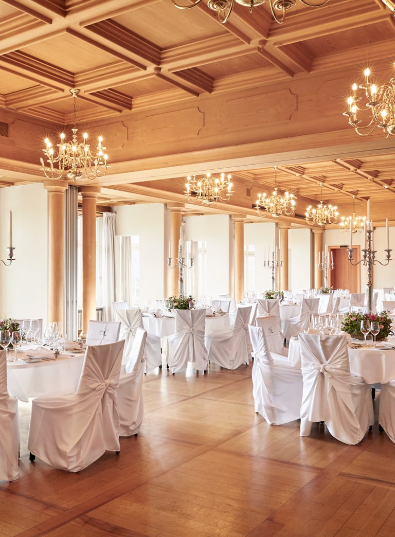 Festlich dekorierter Bankettsaal mit Kronleuchtern.",