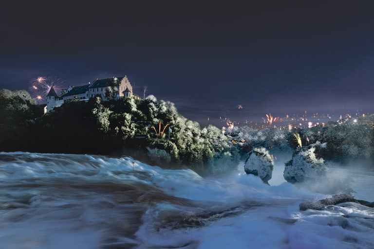 Wasserfall bei Nacht mit Schloss und Feuerwerk im Hintergrund.