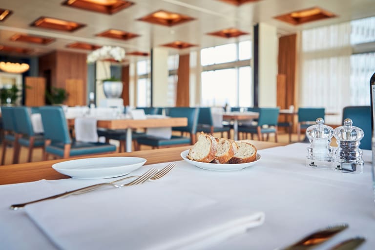 Eleganter Restauranttisch mit Brotteller und Gewürzen.