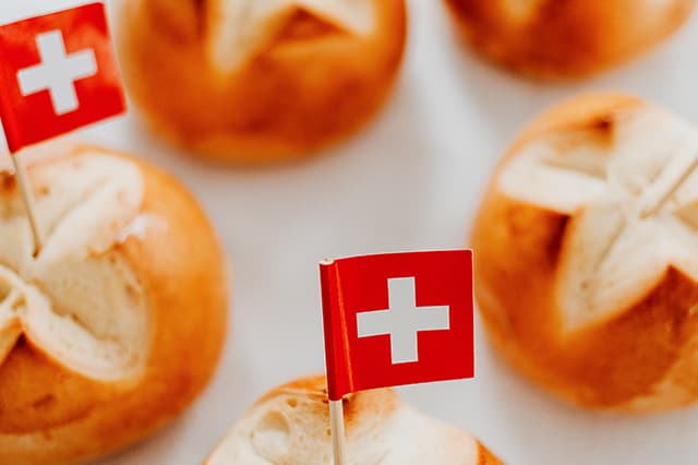 Schweizer Brötchen mit Fahnen auf Tisch.