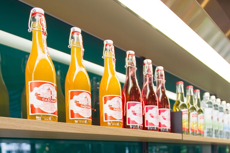 Regal mit bunten Limonadenflaschen in einem Geschäft.