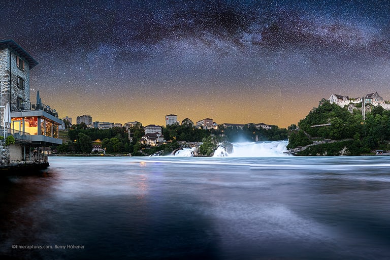 Nachthimmel über Rheinfall mit Gebäuden am Ufer.