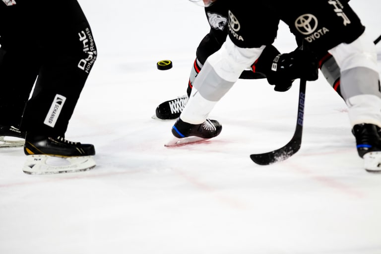 Nahaufnahme von Eishockeyspielern im Kampf um den Puck.