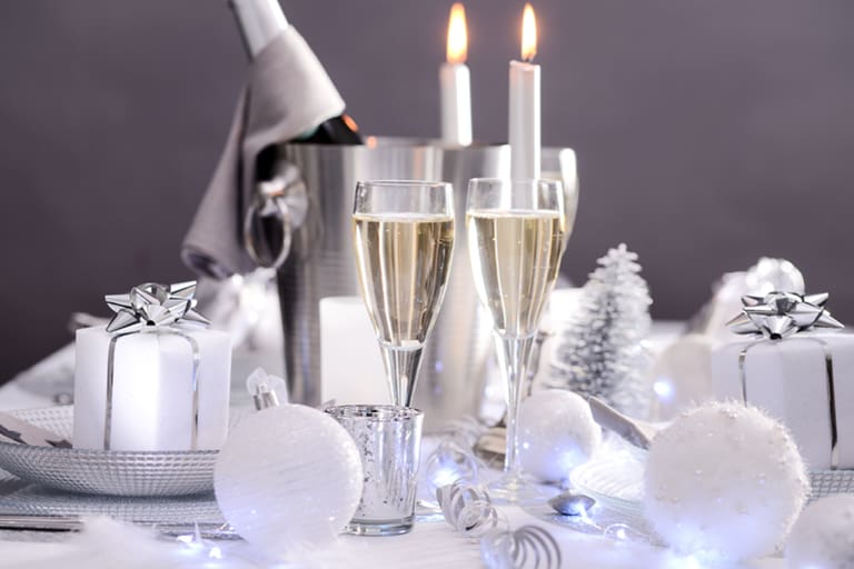 Festliche Tischdekoration mit Geschenken und Kerzen.