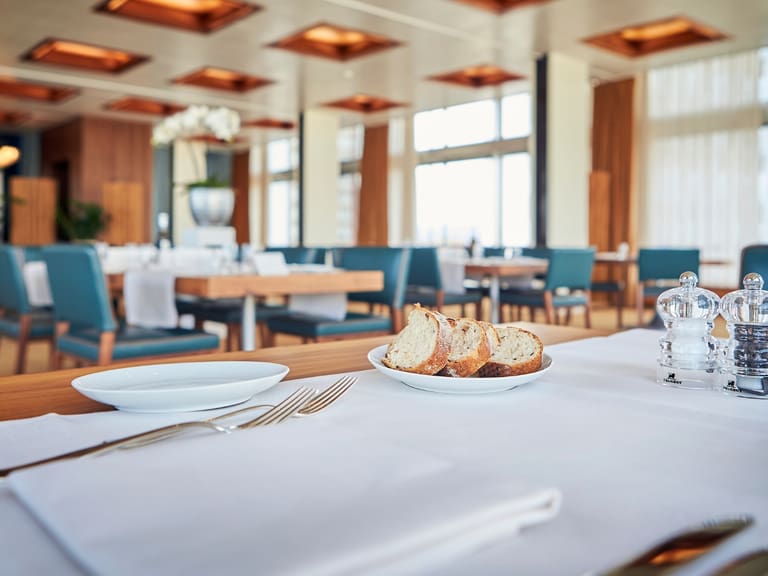 Eleganter Restauranttisch mit Brotteller und Gewürzen.