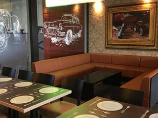 Restaurant mit Autodekor und gemusterten Tapeten.