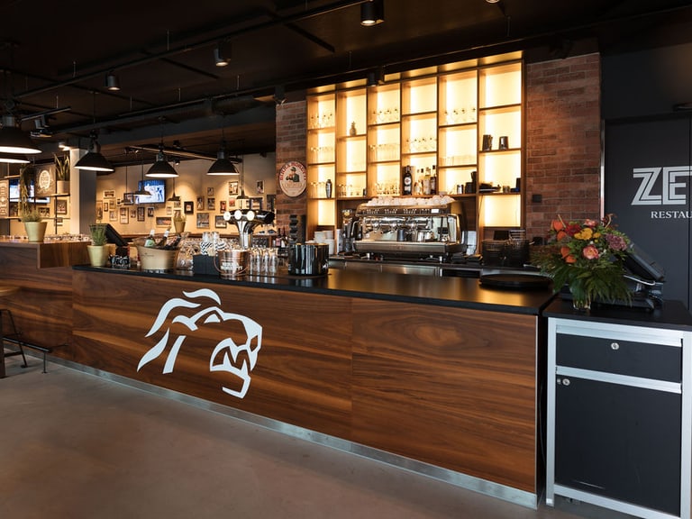 Moderne Bar im ZETT Restaurant mit beleuchteten Regalen.