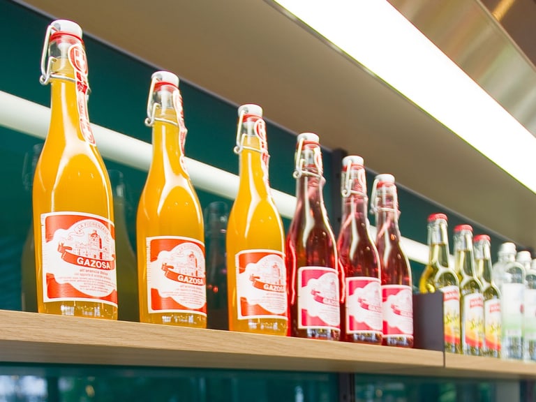 Regal mit bunten Limonadenflaschen in einem Geschäft.