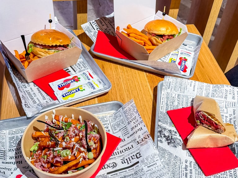 Burger und Pommes auf einem Tisch in einem Bistro.