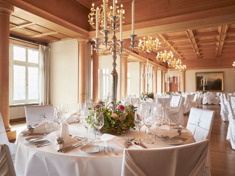 Eleganter Bankettsaal mit gedeckten Tischen und Kronleuchtern.