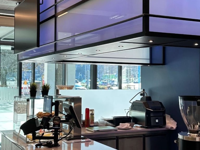 Moderne Cafeteria mit Bestellstation und Geräten.