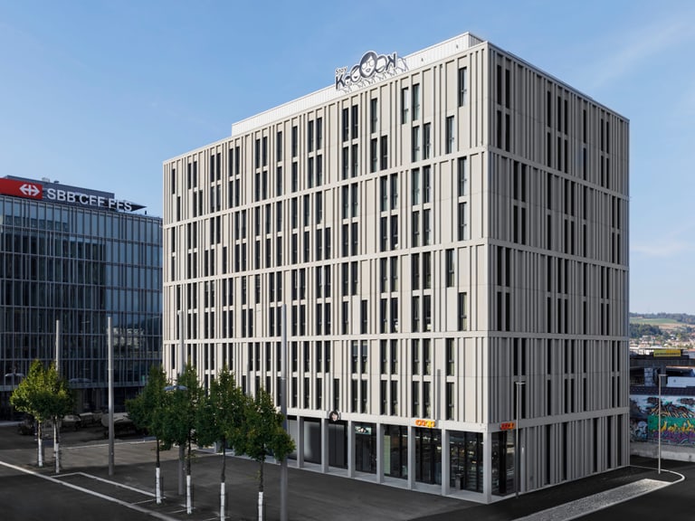Moderne Bürogebäude mit blauem Himmel im Hintergrund.