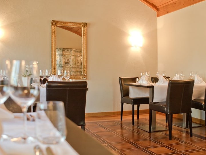 Elegantes Restaurant mit gedeckten Tischen und Spiegel.",