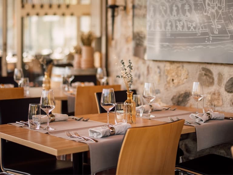 Elegantes Restaurant mit gedeckten Tischen und Steinwänden.