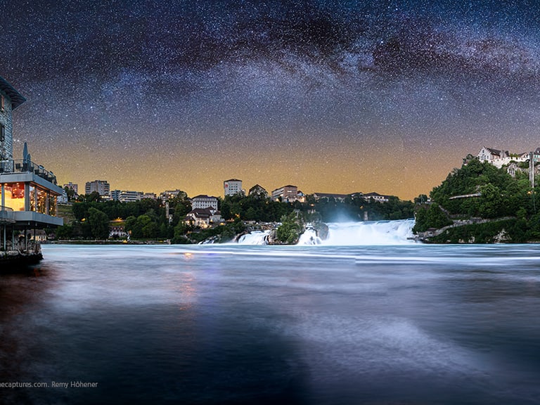 Nachthimmel über Rheinfall mit Gebäuden am Ufer.