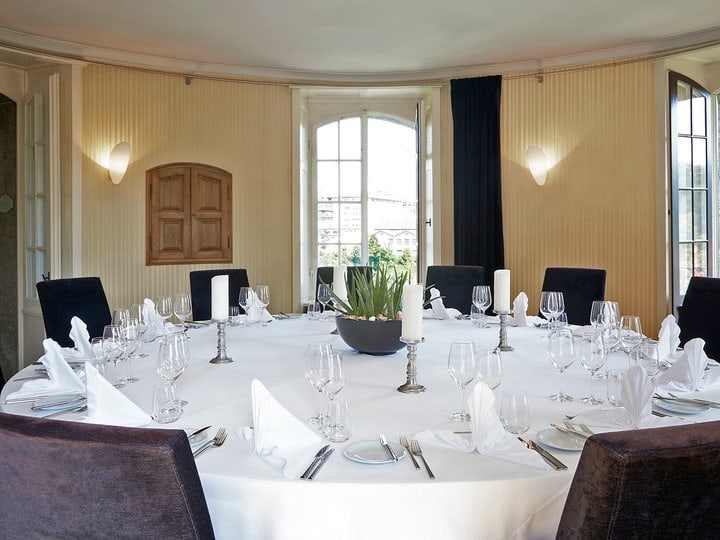 Eleganter runder Esstisch, gedeckt für ein formelles Dinner.