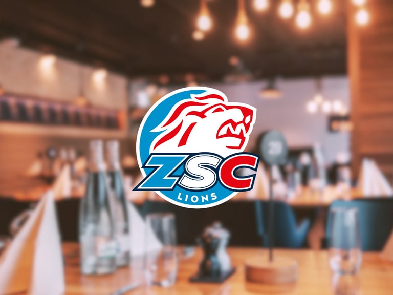 ZSC Lions-Logo über unscharfem Restaurantinterieur.