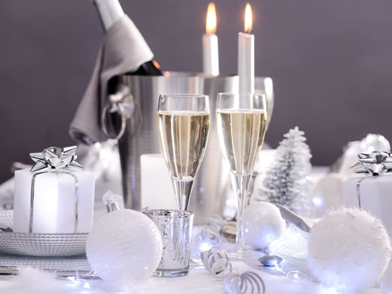 Festliche Tischdekoration mit Geschenken und Kerzen.