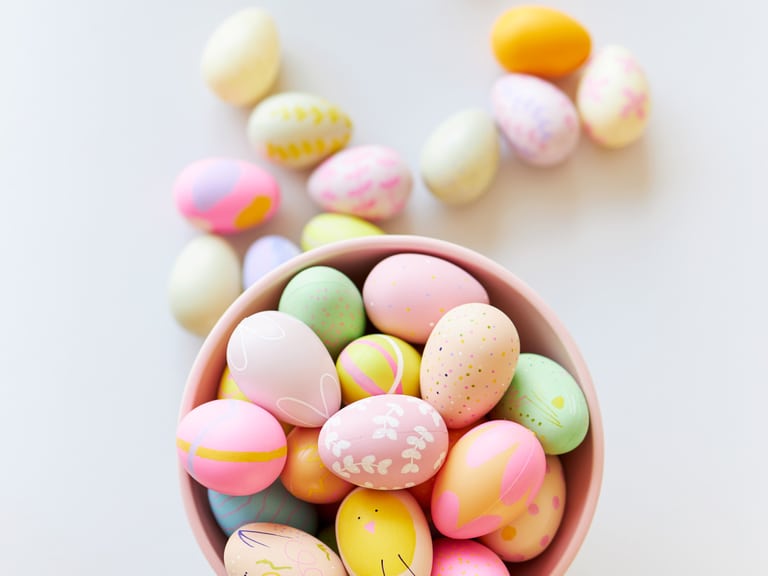 Bunte Ostereier in einer Schüssel auf weissem Hintergrund.