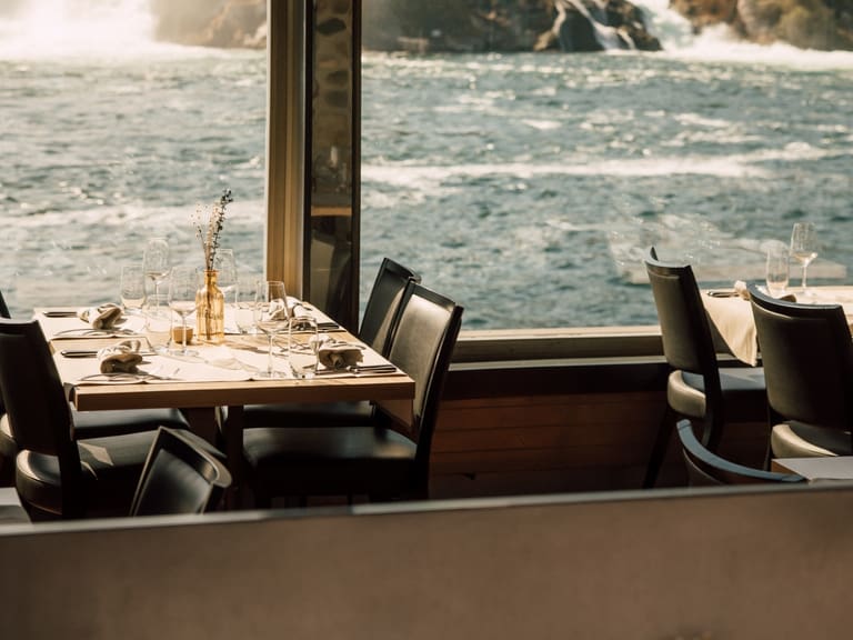 Ein Restauranttisch mit Blick auf einen Fluss.