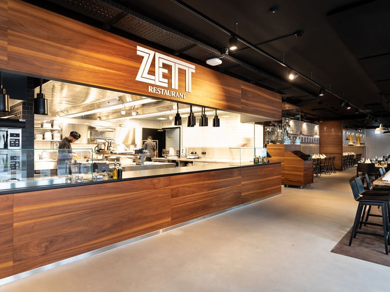 Moderne Restaurantküche mit offenem Design, Zett-Logo sichtbar.