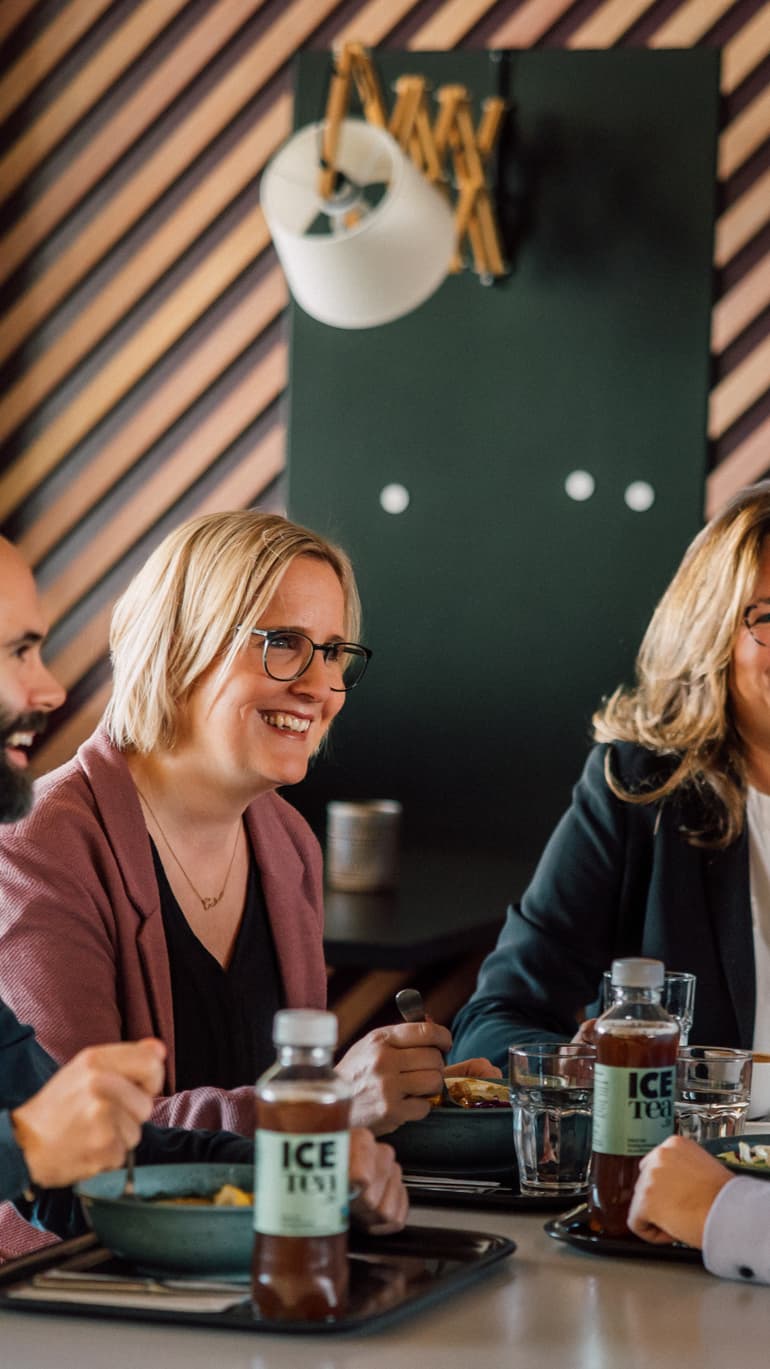 Vier Personen sitzen an einem Tisch mit Getränken.