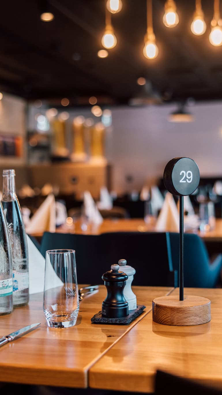 Eleganter Restauranttisch mit Flaschen und Servietten.
