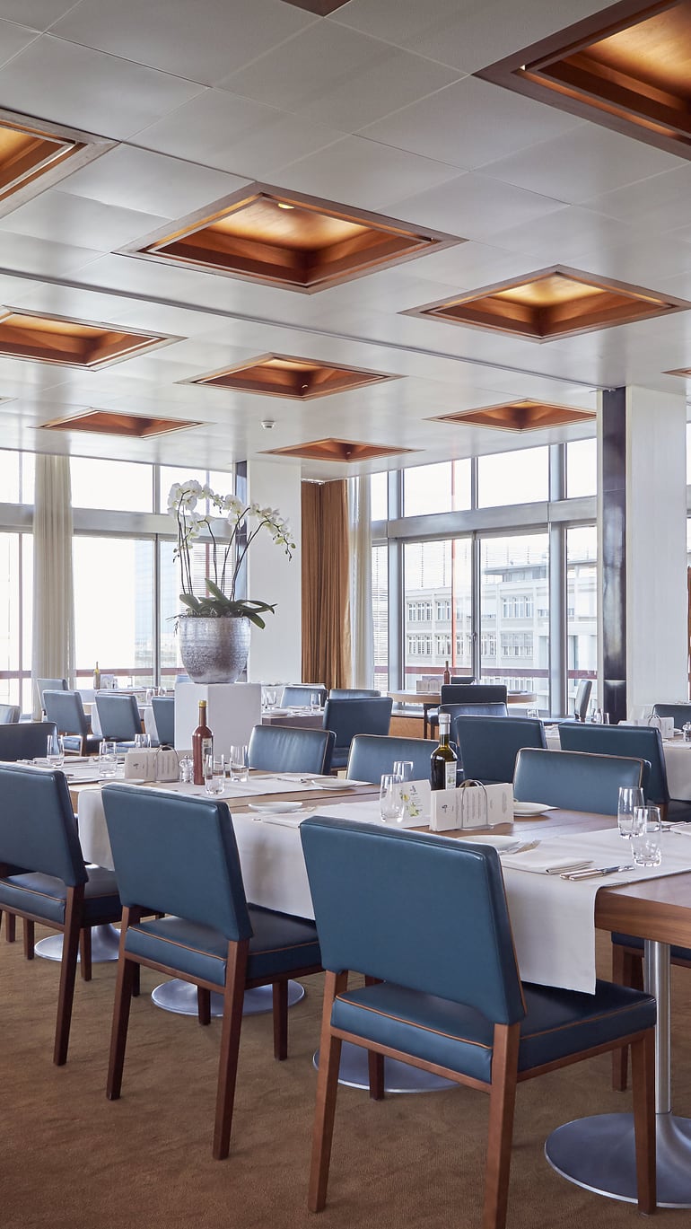 Elegantes Restaurant mit gedeckten Tischen und Panoramafenstern.