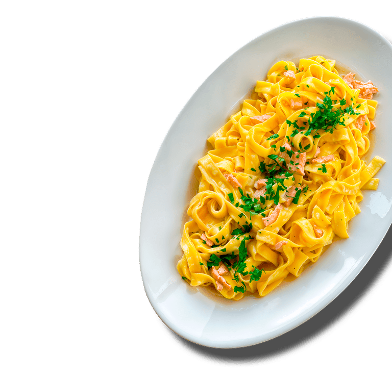 Ein Teller mit Tagliatelle-Pasta auf schwarzem Hintergrund.